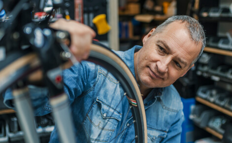 Man inspecting the tire of a bicycle