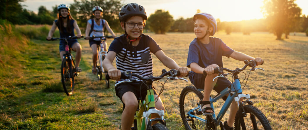 Four kids riding bicycles in a field