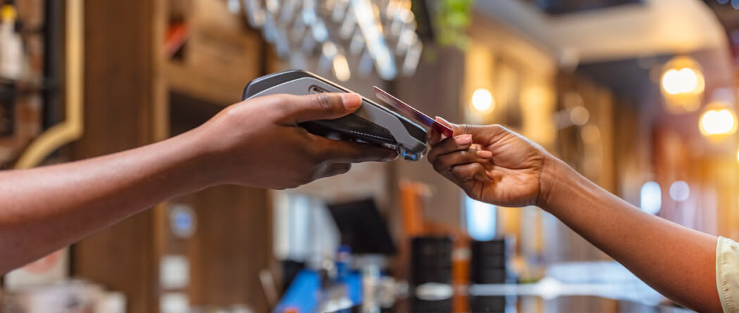 Close up of two hands exchanging a credit card to pay