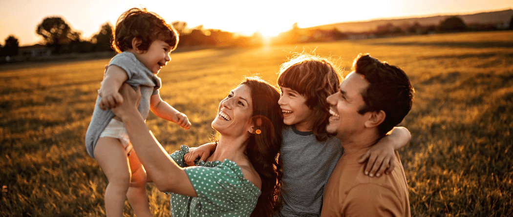 Young family standing in a large field