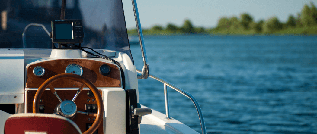 View of a luxury boat steering wheel with water in the background